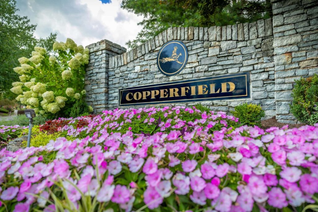 Copperfield Neighborhood Sign surrounded by purple flowers.